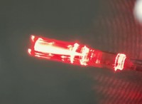 Red_light_through_lens_on_fiber_Roberts_clipped.jpg