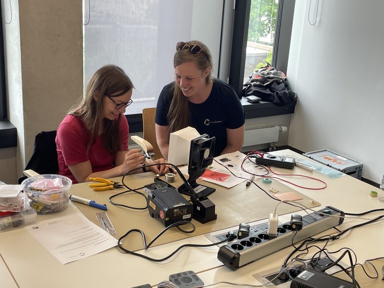 Maike Hansen supports participants with soldering.